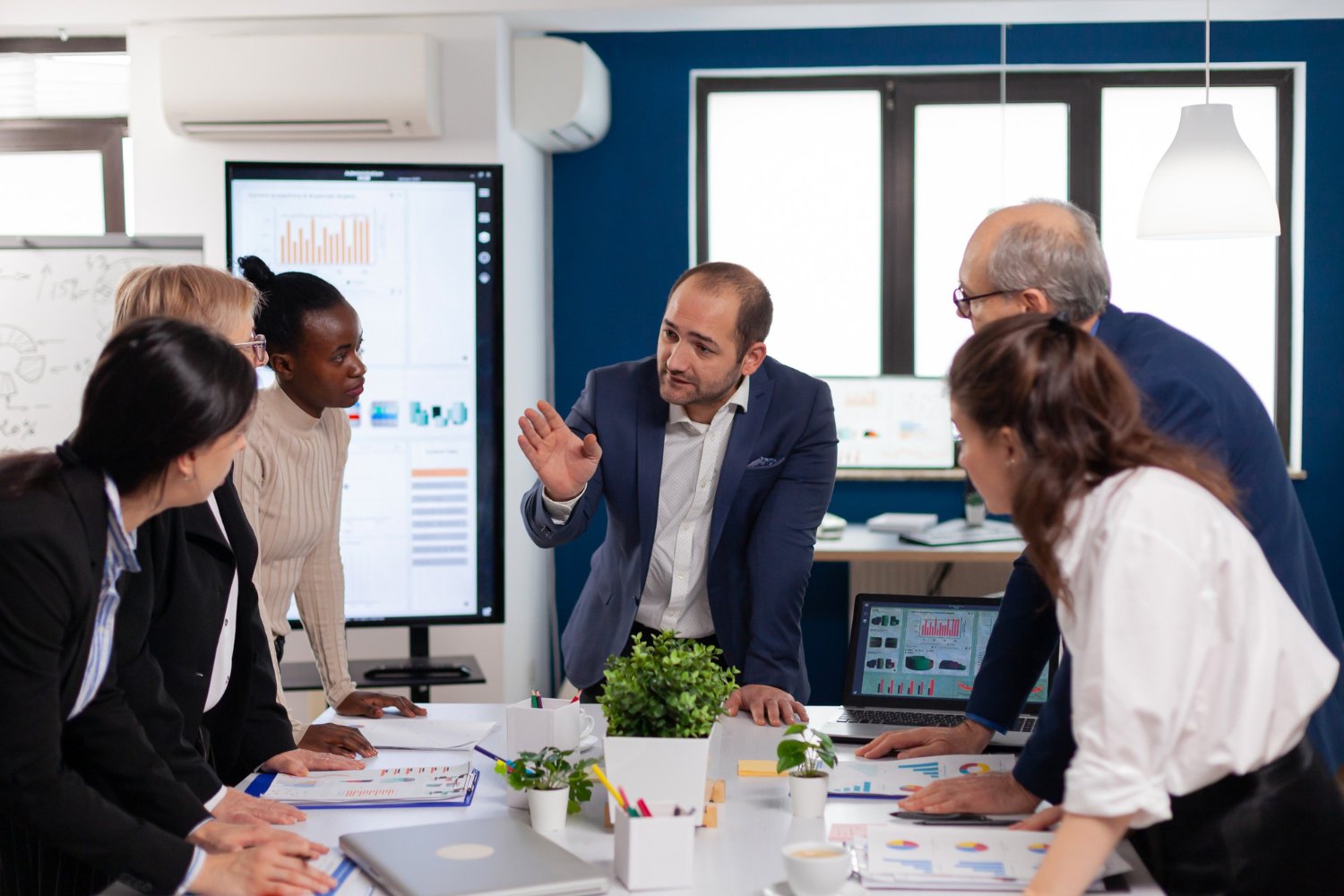 A team gathered around a table, discussing reports and dashboards