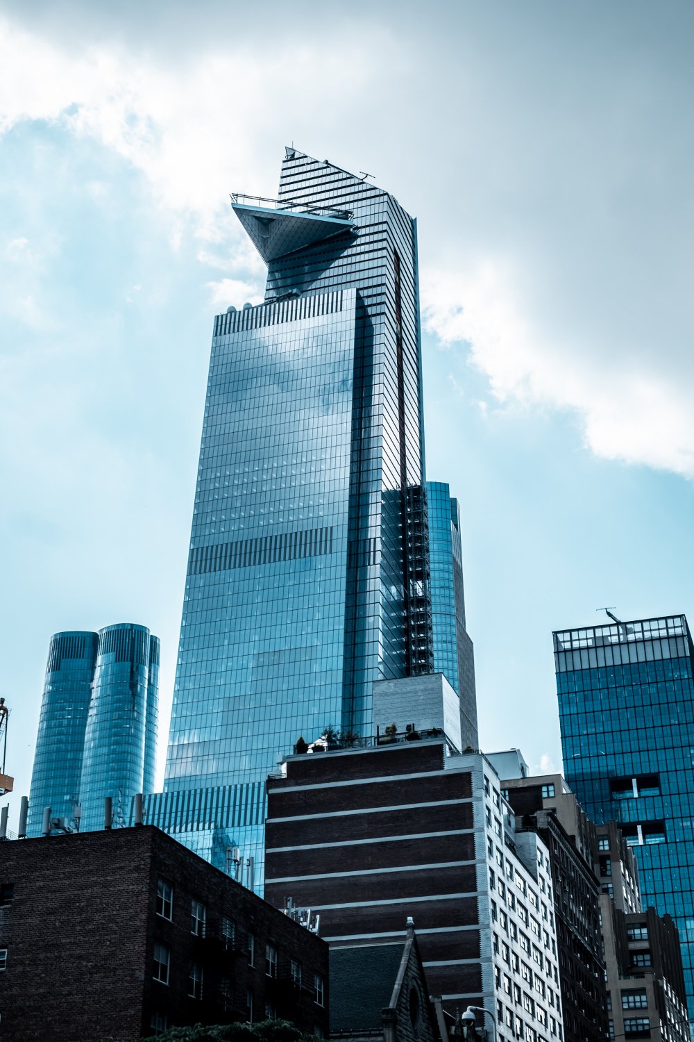 A glass skyscraper viewed from below against the sky